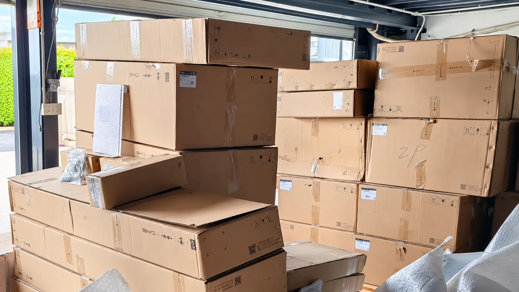 Automotive parts cartons staged near a warehouse loading entrance